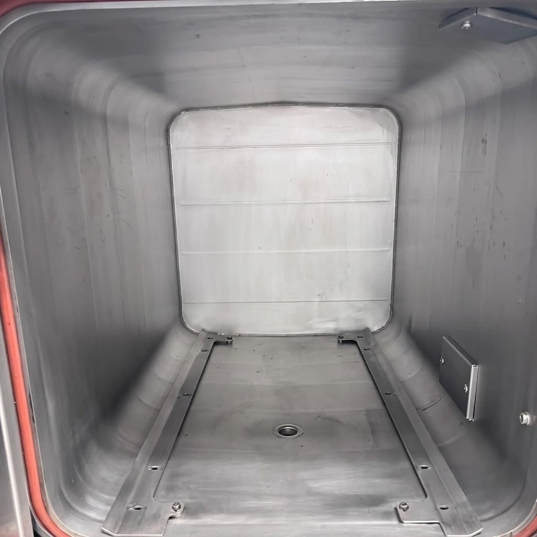 The same sterilizer chamber after cleaning, with bright, restored stainless surfaces