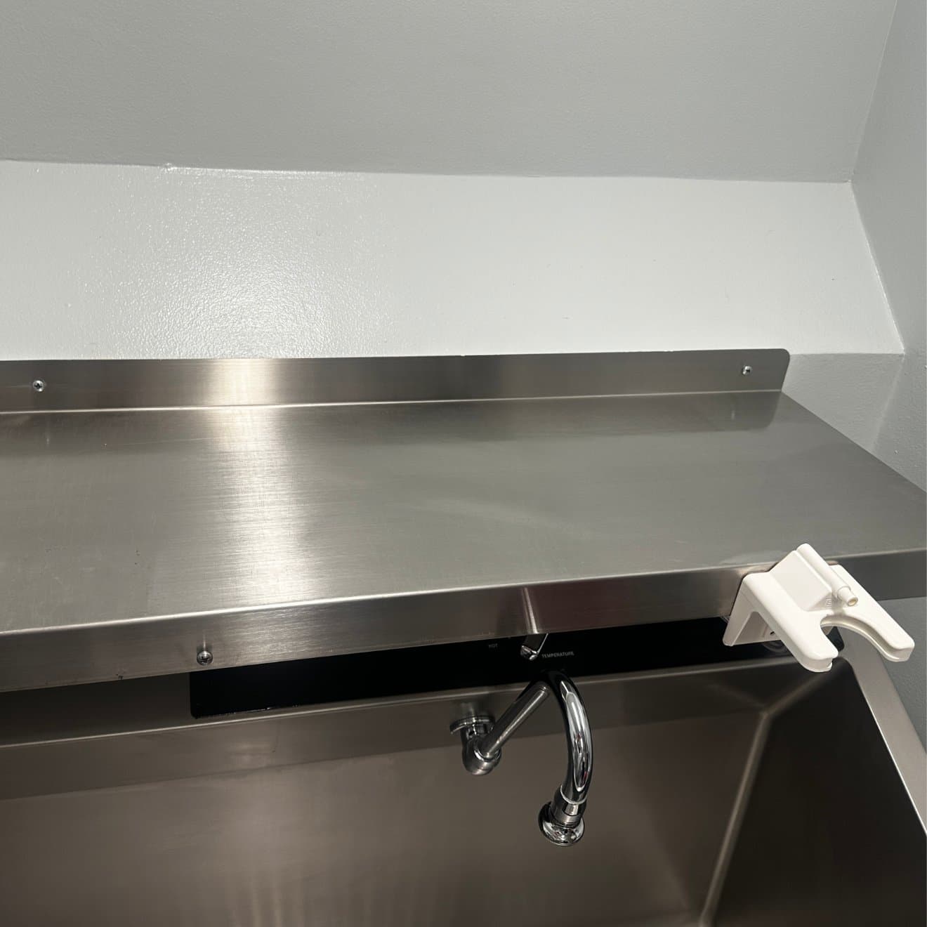 The same stainless steel work surface after deep cleaning, restored to a bright, even finish